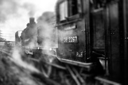 A close up shot of a black locomotive speeding down the tracks